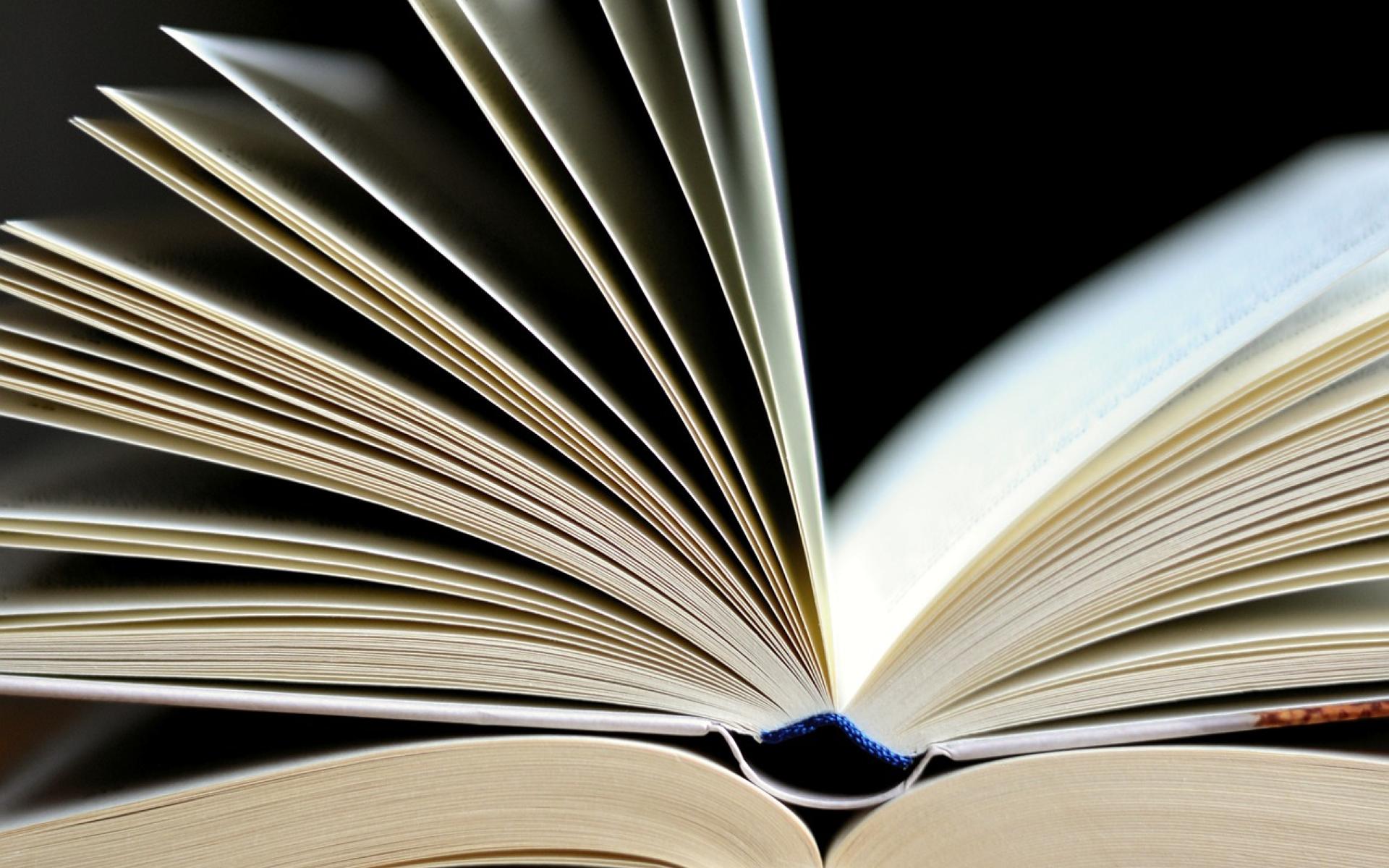 geöffnetes buch auf bücherstapel