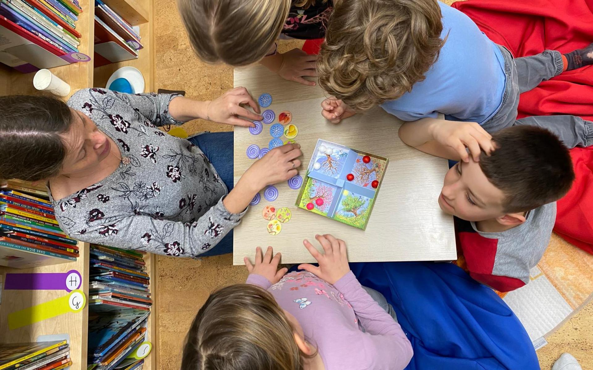 Büchereimitarbeiterin beim Spielen mit Kindern